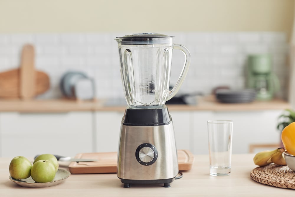 Background image of chrome blender on kitchen counter with fruits, copy space