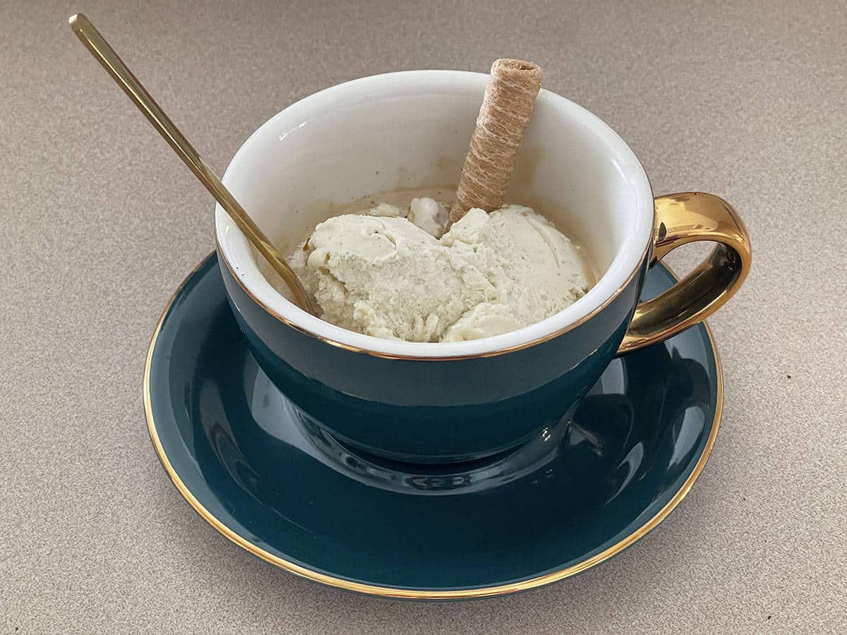 Emerald cappuccino cup with ice cream "drowned" in espresso with a wafer roll garnish