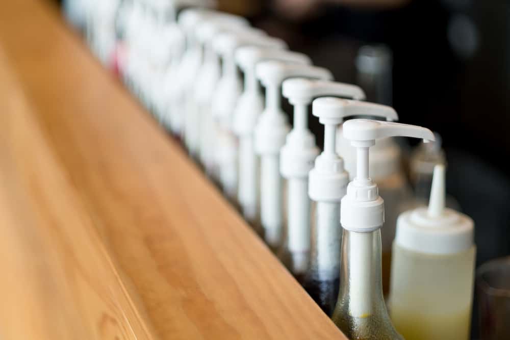 A line of coffee syrups at a coffee shop.