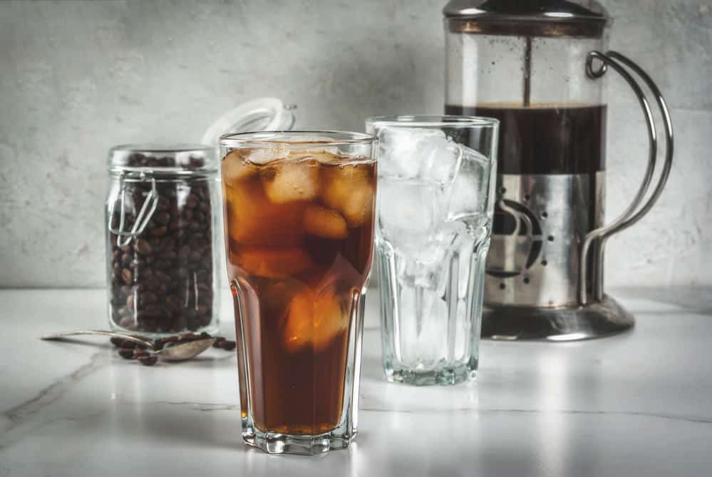 Trendy drinks. Cold brew iced coffee on white marble table. copy space